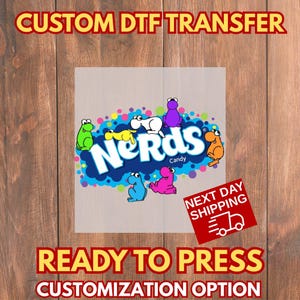 May include: A DTF (Direct to Film) transfer featuring the Nerds Candy logo with colorful cartoon characters. The design includes the text "Custom DTF Transfer", "Ready to Press", and "Customization Option".