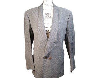 May include: A grey and white patterned blazer with a double-breasted design. The blazer has two rows of buttons and a notched lapel. The jacket is displayed on a mannequin.