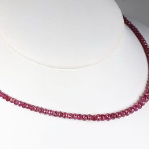 Op de afbeelding: Een delicate roze edelsteen ketting met kleine, ronde kralen. De ketting wordt getoond op een witte mannequinbuste.