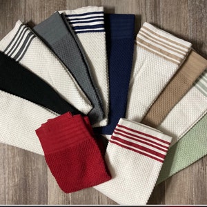 May include: A set of ten kitchen towels in various colors with white waffle weave and colored stripes. The towels are folded and arranged in a fan shape.