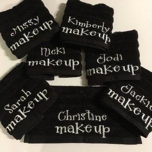 Może przedstawiać: Siedem czarnych ręcznik&oacute;w z białymi haftami. Każdy ręcznik ma imię, po kt&oacute;rym następuje słowo "makeup". Imię to: Missy, Kimberly, Nicki, Jodi, Sarah, Jackie i Christine.