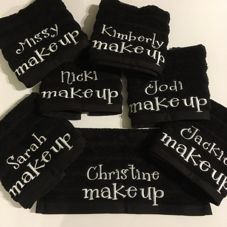 Może przedstawiać: Siedem czarnych ręcznik&oacute;w z białymi haftami. Każdy ręcznik ma imię, po kt&oacute;rym następuje słowo "makeup". Imię to: Missy, Kimberly, Nicki, Jodi, Sarah, Jackie i Christine.