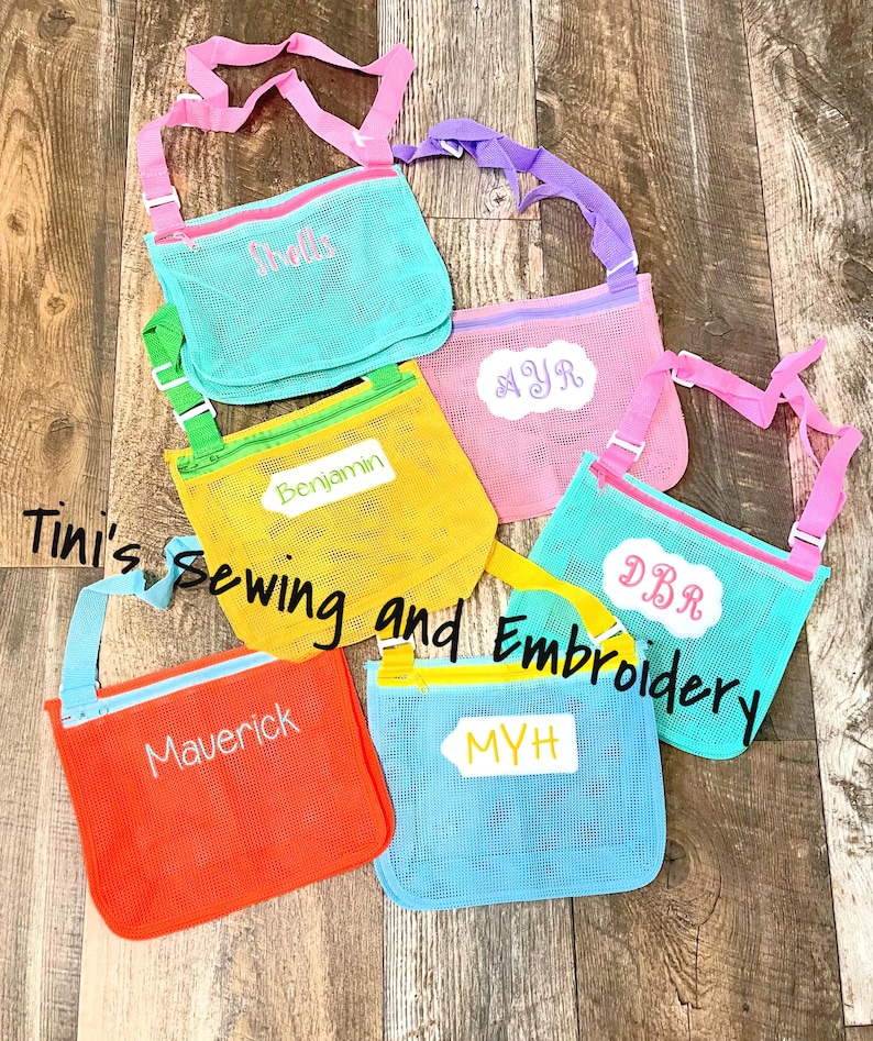 May include: Six colourful mesh bags with adjustable straps and zipper closures. Each bag has a personalised name embroidered on it: Shells, MYR, Benjamin, DBR, MYH, and Maverick.