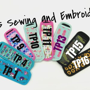 Puede incluir: Una colecci&oacute;n de coloridos aislantes para bebidas con varios dise&ntilde;os, incluyendo flamencos, pi&ntilde;as y unicornios. Cada aislante tiene un borde negro y una etiqueta de texto blanca con un n&uacute;mero TP. El texto "Tini's Sewing and Embroidery" est&aacute; escrito en la parte superior.