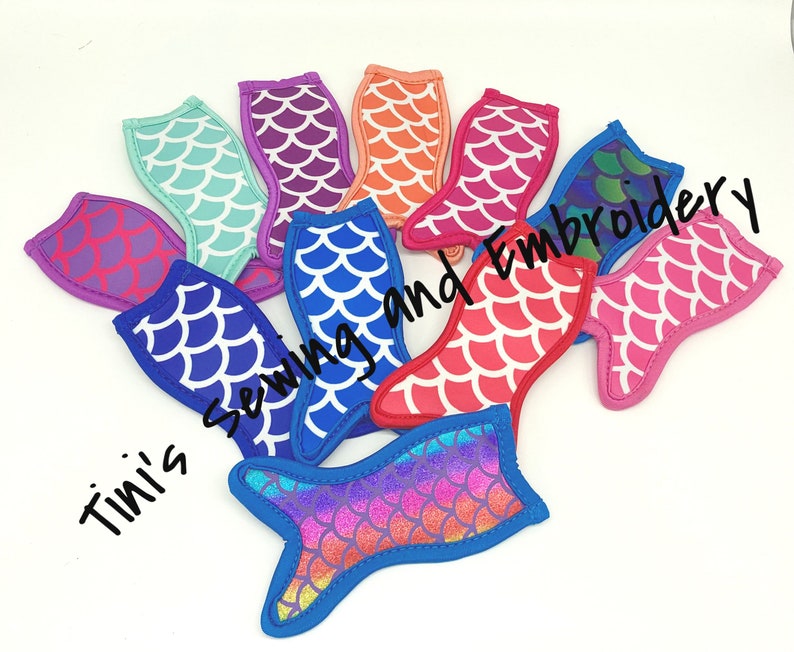May include: A set of ten mermaid tail-shaped can coolers in various colors, including blue, pink, purple, orange, and green. The coolers are made of neoprene and feature a scale pattern. The text "Tini's Sewing and Embroidery" is visible in the image.