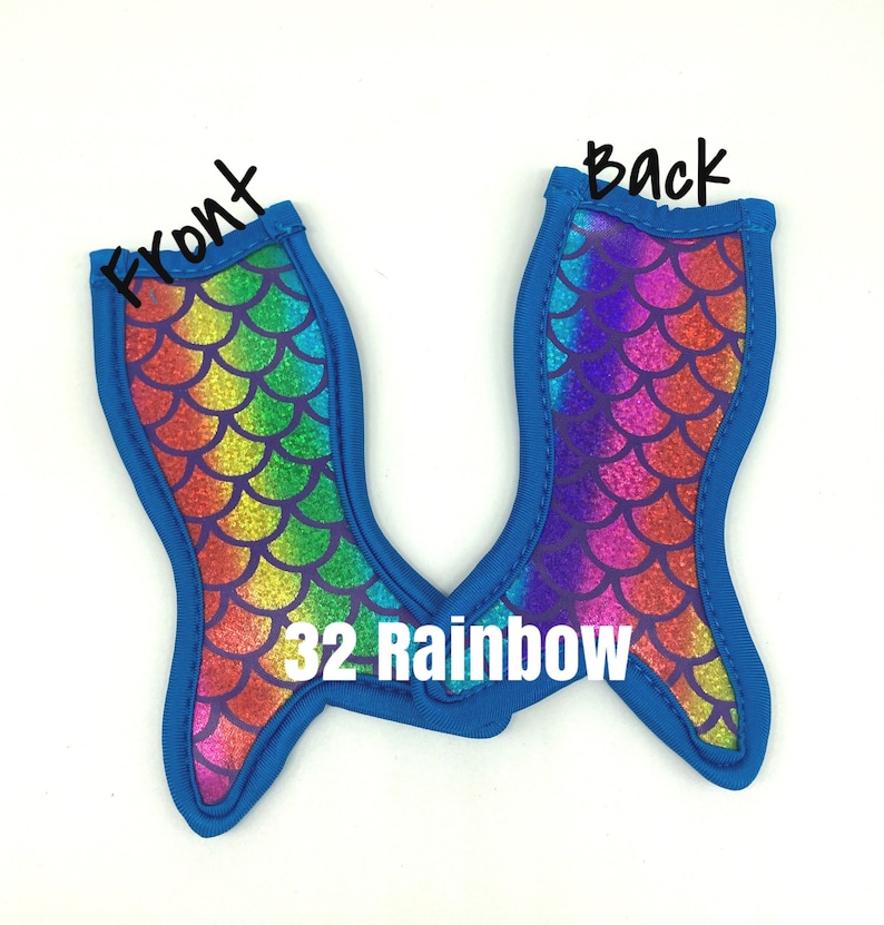 May include: Two blue mermaid tail shaped can coolers with a rainbow glitter pattern. The front of the cooler has a rainbow pattern and the back has a purple and pink pattern. The text "32 Rainbow" is printed on the cooler.