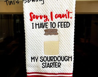 May include: White kitchen towel with red stripes. The towel has embroidered text that reads "Sorry, I can't. I have to feed my sourdough starter."