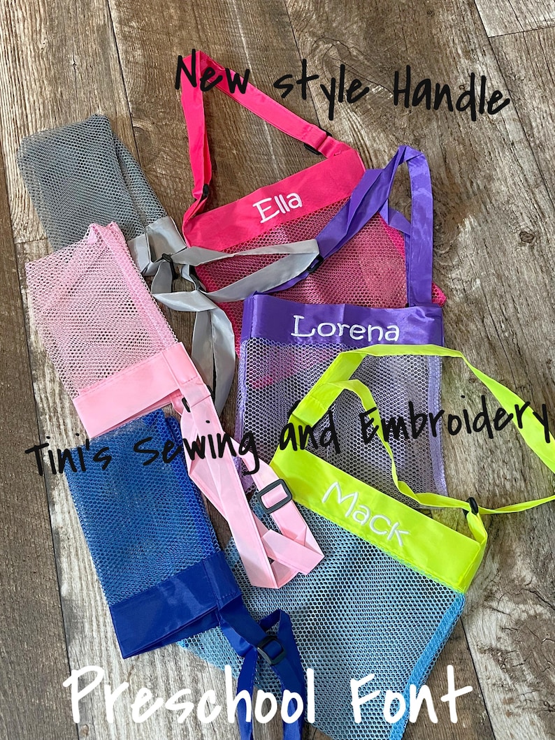 May include: A collection of mesh tote bags in various colors, including pink, purple, blue, and green. Each bag has a contrasting colored handle and the names "Ella", "Lorena", and "Mack" embroidered on them. The text "New style Handle", "Tini's sewing and Embroidery", and "Preschool Font" are also visible.