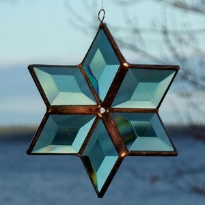 Verwandelnder Kristallstern in Grün und Kupfer, hängender 3D-Sonnenfänger aus geometrisch abgeschrägtem Buntglas, vorgestellt bei Apartment Therapy, hergestellt in Kanada