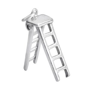 Puede incluir: Un amuleto de plata con forma de escalera. La escalera está hecha de metal y tiene un acabado brillante. El amuleto es perfecto para añadir un toque de fantasía a cualquier pieza de joyería.