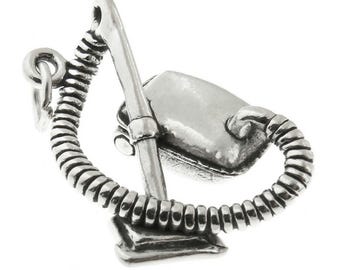 May include: A silver-colored charm in the shape of a vacuum cleaner. The charm features a detailed design of the vacuum head, handle, and hose, with a loop for attachment. The charm is made of a shiny metal.