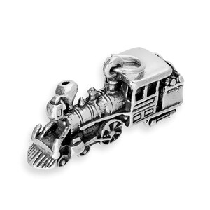 May include: A three-dimensional silver-toned metal charm shaped like a steam locomotive train. The charm features a detailed boiler, a cowcatcher at the front, wheels, and a small circular jump ring attached to the top of the train cabin.