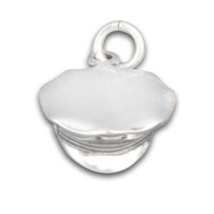 Op de afbeelding: Een zilverkleurige bedel in de vorm van een klassieke pet, met een afgeronde bovenkant en een klep. De bedel heeft een lus aan de bovenkant om aan een ketting of armband te bevestigen. De petbedel is een sieradenaccessoire.