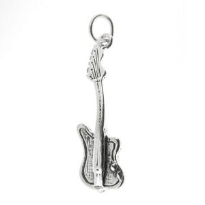 Può includere: Un ciondolo a forma di chitarra color argento con un anello nella parte superiore per il fissaggio a una collana o un braccialetto. Il ciondolo è una replica in miniatura dettagliata di una chitarra elettrica, con corpo, manico e paletta.