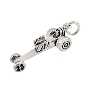 May include: A silver charm in the shape of a dragster race car. The charm has a detailed design with a visible engine and wheels.