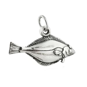 Può includere: Un ciondolo a forma di pesce argentato con un anello per attaccarlo a una collana o un braccialetto. Il ciondolo è una rappresentazione dettagliata di un pesce piatto, con pinne e squame visibili. Il ciondolo è progettato per essere un pendente.