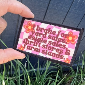 May include: A pink and white checkered patch with a brown flower design and the text "I brake for yard sales, estate sales, thrift stores & farm stands."