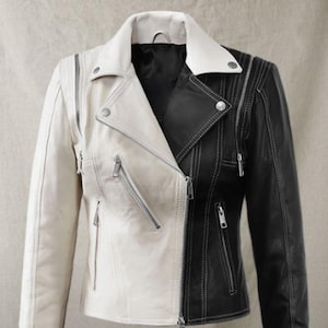 Peut inclure: Une veste en cuir noire et blanche avec une fermeture éclair. La veste a un design bicolore contrasté, avec un côté noir et l'autre côté blanc.