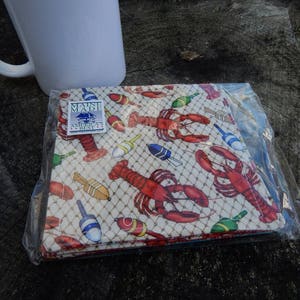 Puede incluir: Un juego de cuatro posavasos de tela blanca con un dise&ntilde;o de langosta y boya. Los posavasos est&aacute;n empaquetados en una bolsa de pl&aacute;stico transparente y llevan una etiqueta "Maine Made".