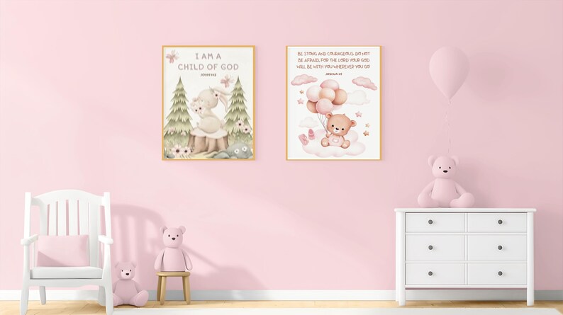 Side-by-side framed nursery prints on a pink wall: one with a bunny and John 1:12, the other with a teddy bear and Joshua 1:9. Displayed above a dresser and next to a white rocking chair and teddy bear.