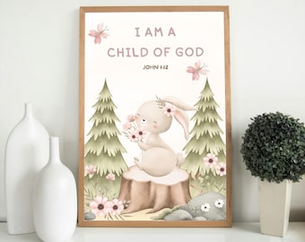 May include: A framed print with a light wood frame featuring a watercolor illustration. The artwork depicts a bunny holding flowers, sitting on a tree stump, with the text "I AM A CHILD OF GOD" and John 1:12. The background includes trees and flowers.