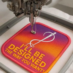 Könnte beinhalten: Eine Stickmaschine stickt einen quadratischen Aufnäher mit einem Farbverlauf aus Pink, Orange und Gelb. Der Aufnäher trägt den gelben Text "I'LL BE DESIGNED THE WAY YOU WANT!" und ein weißes Nadel- und Fadendesign.