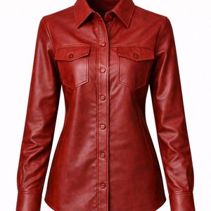 Puede incluir: Una camisa de cuero roja con cuello, dos bolsillos en el pecho y mangas largas. La camisa tiene una botonadura frontal y pu&ntilde;os abotonados. La prenda es de color rojo intenso.