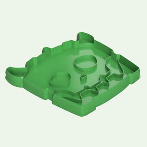 May include: Green plastic cookie cutter shaped like a cartoon monster with a skull face. The cutter has two horns, two eyes, and a mouth with teeth.