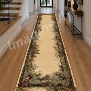 May include: A long, rectangular beige runner rug with a nature-inspired design. The rug features a border of pine needles, pine cones, and branches in shades of green and brown. The rug is placed on a wooden floor.