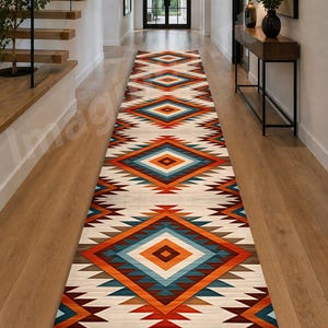 Puede incluir: Una alfombra de pasillo larga con un patrón geométrico repetitivo de grandes diamantes en tonos naranja, azul verdoso, marrón y crema. El diseño incluye bordes en zigzag angulares y formas de diamante anidadas a lo largo de la alfombra.
