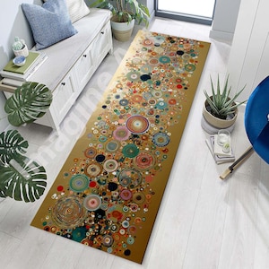 Könnte beinhalten: Ein rechteckiger Teppich mit goldenem Hintergrund und einem Muster aus bunten, sich überlappenden Kreisen. Die Kreise variieren in Größe und Farbe, darunter Rot, Blau, Grün und Gelb. Der Teppich liegt auf einem hellen Holzboden.