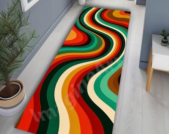 Op de afbeelding: Een kleurrijk retro-stijl loper met een golvend patroon. De loper heeft strepen in rood, oranje, geel, groen en bruin. De rechthoekige loper lijkt van een zacht materiaal te zijn gemaakt.