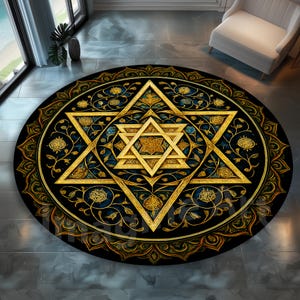 May include: A round black rug with a gold Star of David design at the center. The rug features intricate floral and geometric patterns in gold, blue, and green. The rug is placed on a gray tiled floor.