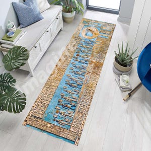 May include: An Egyptian-themed runner rug with a central blue panel featuring hieroglyphs and figures. The rug has a beige border with more hieroglyphs and a circular design at the top. The rug is rectangular and designed for a hallway or entryway.