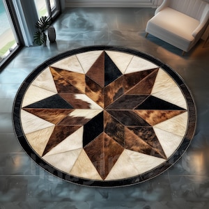 May include: A round cowhide rug with a starburst design. The rug features a central star pattern in shades of brown, black, and cream, surrounded by a cream-colored border and a black outer edge. The rug is a decorative floor covering.