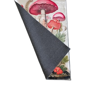 May include: Rectangular rug featuring a botanical illustration of vibrant red and pink mushrooms with green foliage. The rug's underside is a dark gray, textured material. The words "SAMPLE MODEL" are printed at the bottom.