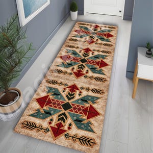May include: A rectangular beige rug with a geometric pattern in red, teal, and black. The design features stylized arrows and diamond shapes. The rug is placed in a hallway, adding a decorative element to the space.