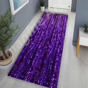May include: A rectangular purple mosaic patterned rug. The rug is made of small, square tiles that reflect light, creating a shimmering effect. The rug is placed in a hallway, adding a touch of color and texture to the space.
