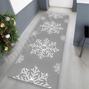 Könnte beinhalten: Ein rechteckiger grauer Teppich mit Schneeflockenmuster. Große, glitzernde silberne Schneeflocken sind über die Oberfläche des Teppichs verteilt. Der Teppich ist für einen Flur oder Eingangsbereich geeignet und verleiht der Inneneinrichtung eine festliche Note.