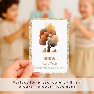 K&ouml;nnte beinhalten: Eine rechteckige Karte mit einer Aquarellillustration eines Baumes mit braunen, orangefarbenen und gelben Bl&auml;ttern. Das Wort &bdquo;GROW&ldquo; steht unten, darunter der Text &bdquo;like a Tree&ldquo;. Die Karte wird vor drei Kindern gehalten.