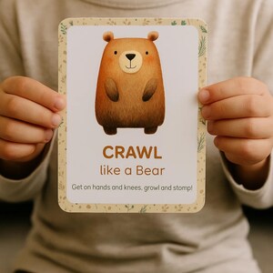 K&ouml;nnte beinhalten: Eine rechteckige Karte mit einer Cartoon-B&auml;ren-Illustration. Der B&auml;r ist braun mit einer schwarzen Nase und Augen. Auf der Karte steht "CRAWL like a Bear" mit Anweisungen darunter. Die Karte hat einen dekorativen floralen Rand.