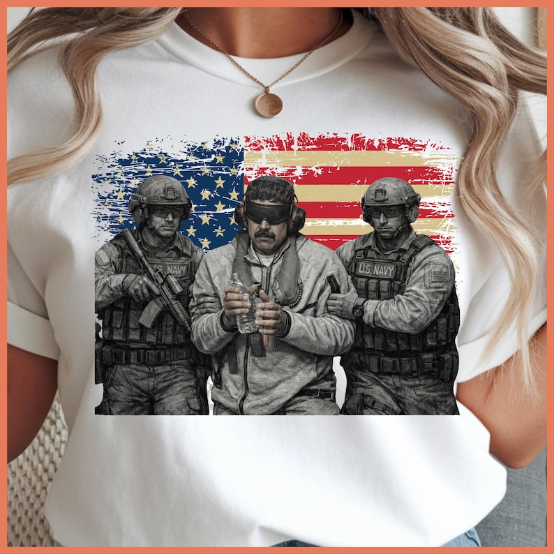 May include: White t-shirt featuring a graphic of three soldiers in military gear, standing in front of a distressed American flag. The soldiers are in shades of gray and black, with the words "U.S. NAVY" visible on their uniforms.