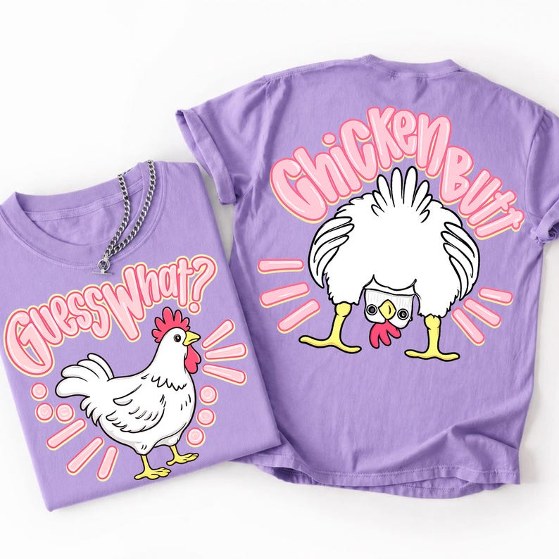 Puede incluir: Dos camisetas lavanda con gr&aacute;ficos de pollos. Una camiseta presenta un pollo blanco con el texto "Guess What?" en rosa. La otra camiseta tiene el trasero de un pollo con el texto "Chicken Butt" en rosa.