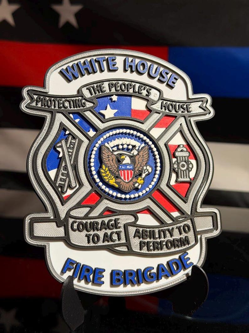 May include: A multi-layered, shield-shaped emblem featuring the text WHITE HOUSE, THE PEOPLE'S HOUSE, PROTECTING, COURAGE TO ACT, ABILITY TO PERFORM, and FIRE BRIGADE. The center displays a bald eagle seal, with icons of a ladder and fire hydrant.