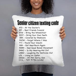 May include: White throw pillow with black text that reads "Senior citizen texting code" and a list of abbreviations and their meanings. The abbreviations are related to common senior citizen experiences.