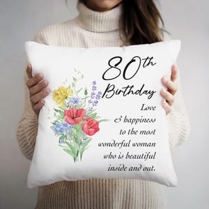 May include: White pillow with a floral design and the text "80th Birthday Love & happiness to the most wonderful woman who is beautiful inside and out."