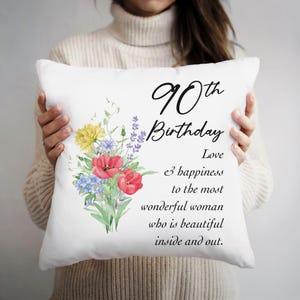 May include: White square pillow with the text "90th Birthday" and a floral bouquet. The pillow also includes the text "Love & happiness to the most wonderful woman who is beautiful inside and out."