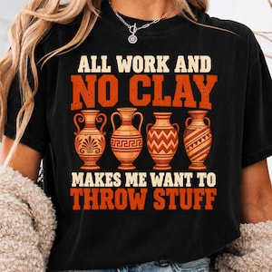 May include: A black short-sleeve t-shirt featuring the text ALL WORK AND NO CLAY MAKES ME WANT TO THROW STUFF in orange and cream. The graphic includes four distinct orange and cream pottery vases with various geometric and floral patterns.