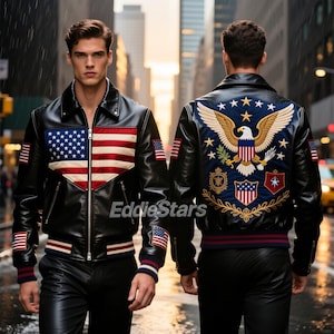 May include: Black leather jacket featuring the American flag design on the front and an embroidered eagle on the back. The jacket has a zip-up front, ribbed cuffs, and a collar. The jacket also has American flag patches on the sleeves.
