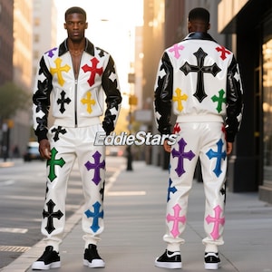 Könnte beinhalten: Weißes Lederjacken- und Hosen-Set mit bunten Kreuz-Designs. Die Jacke hat schwarze Ärmel und einen Kragen. Die Hosen und die Jacken zeigen Kreuze in Schwarz, Rot, Gelb, Grün, Lila und Blau. Der Text "EddieStars" ist sichtbar.